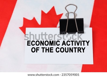 Economy and finance concept. On the flag of Canada lies a business card with the inscription - economic activity of the country.