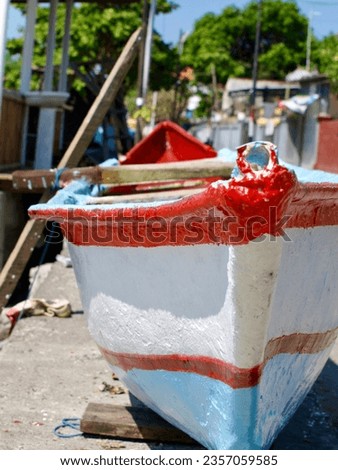     A small fishing boat on renovation. A beautiful sunny day in industrial area of Bali. 