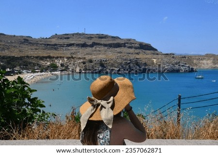 woman with a hat facing the sea in Greece