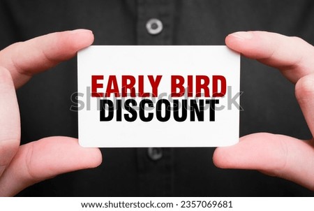 Businessman holding a card with text EARLY BIRD DISCOUNT , business concept