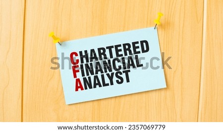 CHARTERED FINANCIAL ANALYST sign written on sticky note pinned on wooden wall
