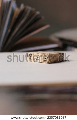 a close-up aesthetic shot of wooden stamping letters for paper crafts arranged on a table and surrounded by journals