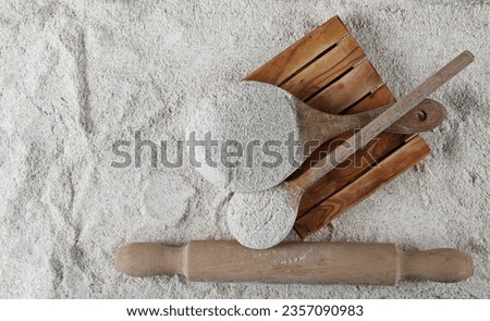 Pile of integral whole grain barley flour in wooden spoon, top view  Royalty-Free Stock Photo #2357090983