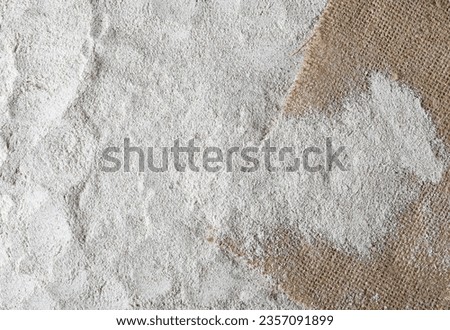 Pile of integral whole grain barley flour and jute, linen sack background and texture, top view  Royalty-Free Stock Photo #2357091899