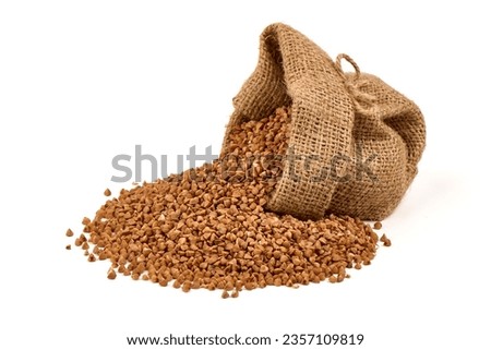 Raw buckwheat grains in rustic burlap isolated on white background Royalty-Free Stock Photo #2357109819