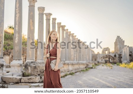 Pretty tourist woman at the ruins of ancient city of Perge near Antalya Turkey Royalty-Free Stock Photo #2357110549