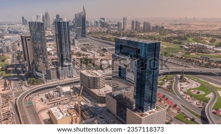 Aerial view of media city and al barsha heights district with golf course during all day from Dubai marina with shadows moving fast. Towers and skyscrapers with traffic on a highway from above Royalty-Free Stock Photo #2357118373