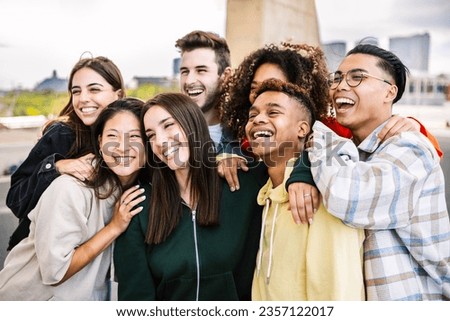 Diverse teenage student people standing together outdoors posing for group photo. Gen z multiethnic friends having fun, laughing and enjoying free time in city street.