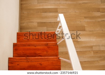 wood stair with white steel railing on wooden parquet floor 