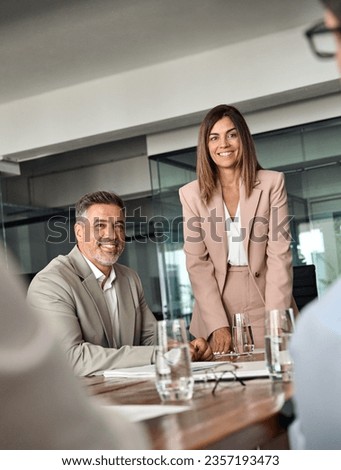 Happy professional board executive colleagues successful business team people collaborating having corporate teamwork discussion together at group office conference meeting boardroom table. Vertical Royalty-Free Stock Photo #2357193473