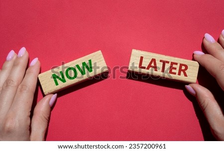 Now vs Later symbol. Concept word Now vs Later on wooden blocks. Businessman hand. Beautiful red background. Business and Now vs Later concept. Copy space