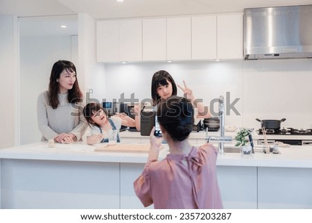 A grandmother taking pictures of her grandchildren with her phone