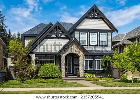 Real Estate Exterior Front House on a sunny day. Big modern custom made luxury house with nicely landscaped front yard in summer. Beautiful house entrance with a green lawn. Perfect neighborhood Royalty-Free Stock Photo #2357205541