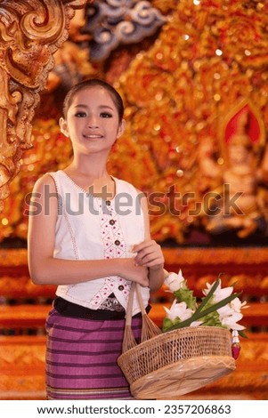 A Thai young girl dressed in traditional costumes visits a Sridonmoon temple in Chiang Mai, Thailand. Asian teenagers in traditional costumes at Thai Temple