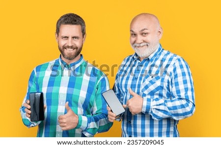 photo of glad generation men showing phone app. generation men showing phone app