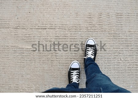 Selfie of sneakers on the concrete floor background with copy space.