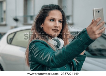 urban woman with phone taking a selfie or live video