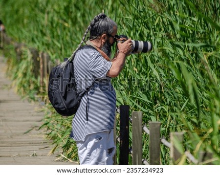 a photographer taking pictures of birds on a nature walk