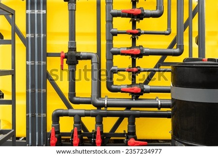 lots of pipes and cranes on a yellow background. water supply system.