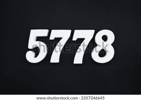 Black for the background. The number 5778 is made of white painted wood.