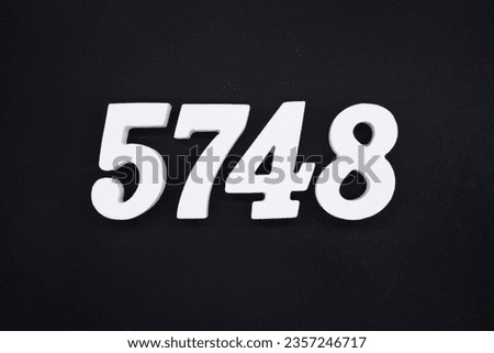 Black for the background. The number 5748 is made of white painted wood.