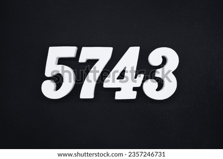 Black for the background. The number 5743 is made of white painted wood.