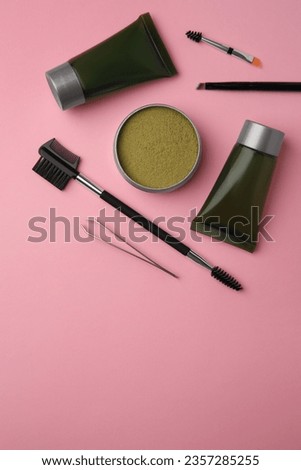 Flat lay composition with eyebrow henna and tools on pink background. Space for text
