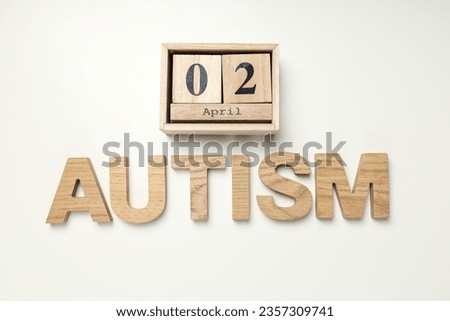 The word "autism" in wooden letters on a light background.World autism awareness day concept
