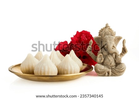Idol of lord Ganesha with Modak Sweet Dish and flower. Ganesh chaturthi Royalty-Free Stock Photo #2357340145