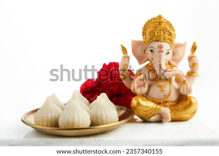 Idol of lord Ganesha with Modak Sweet Dish and flower. Ganesh chaturthi Royalty-Free Stock Photo #2357340155