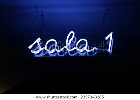 Blue neon sign indicating room 1