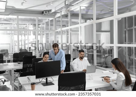Colleagues working together in open plan office