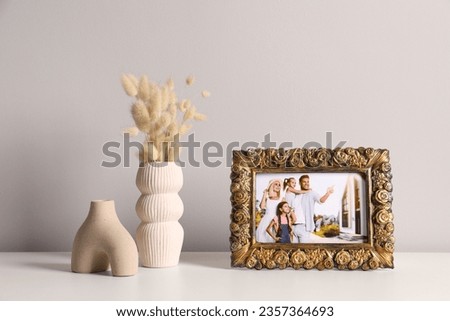 Vintage square frame with family photo and other decor elements on white table