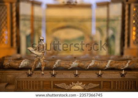 Wooden figurine of an Italian comedy character on the stage of an old miniature puppet theater