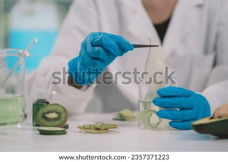 A reseracher using a tweezers to hold a round slice of fruits in cosmetic lab for beuty. fruits has nutritional value and great health benefits