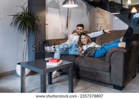 A Caucasian couple watching online series on their modern home television, lifestyle of a couple on a romantic evening. Domestic lifestyle.