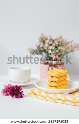 Minimalistic image of stacked cookies with a cup of tea with white background 