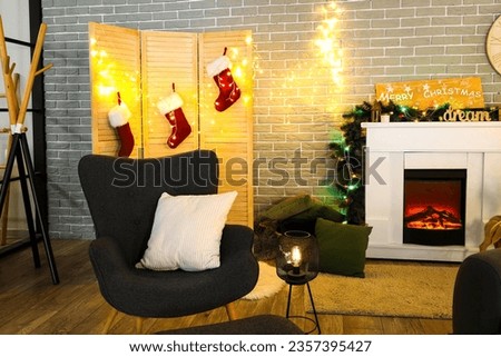 Interior of living room with fireplace, armchair and Christmas decorations