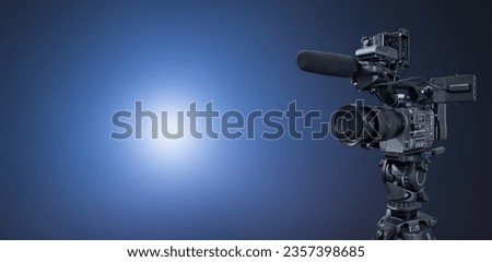 Digital movie camera on blue wide banner background with copy space for film production or television broadcast website design Royalty-Free Stock Photo #2357398685