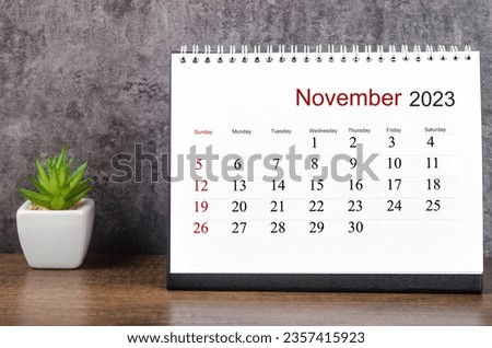 November 2023 Monthly desk calendar for 2023 year on wooden table.