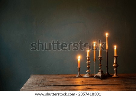 burning candles in vintage candlesticks on dark background Royalty-Free Stock Photo #2357418301