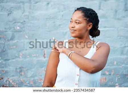 Black woman pointing finger to show advertising, promo or commercial mockup, marketing space on blue wall outdoor gen z, youth lifestyle. African girl or student with hand sign to information mock up