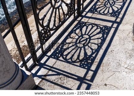 Close-up of abstract shadow pattern of metal railing at Grand Canal at Italian City of Venice on a sunny summer day. Photo taken August 7th, 2023, Venice, Italy.