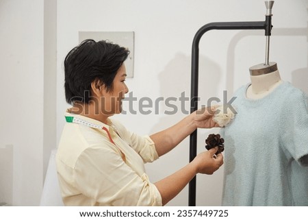 Asian Female Tailor at work on the studio