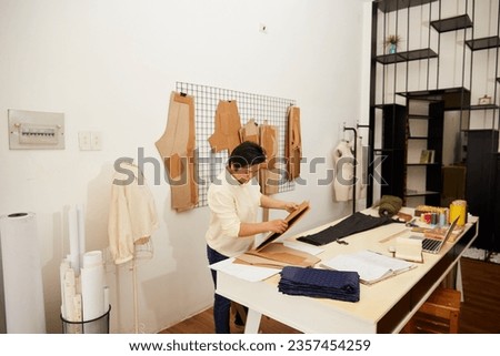 Asian Professional Female Tailor Working At Workshop
