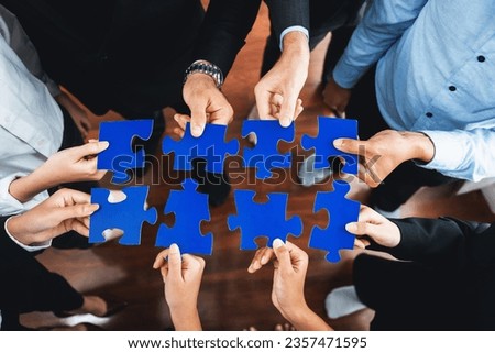 Top view multiethnic business people holding jigsaw pieces and merge them together as effective solution solving teamwork, shared vision and common goal combining diverse talent. Meticulous Royalty-Free Stock Photo #2357471595