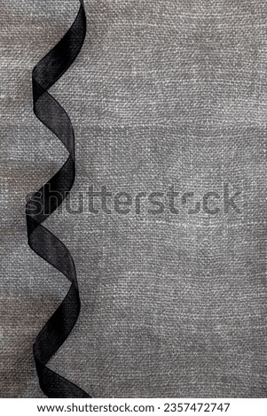 curly black bow on gray texture background. concept background for halloween or all saints day Royalty-Free Stock Photo #2357472747
