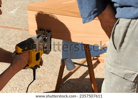 Carpenter working with a jig saw beech wood. Carpentry work for the home integral reform. Royalty-Free Stock Photo #2357507611