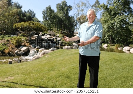 Vacation. A man smiles as he poses for pictures while on Vacation. Tropical Island Vacation. Hawaiian Island. Beautiful Park and Nature. Outside in the sunshine. Sports and Recreation. Happy People. 