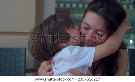 Little boy embracing mother in authentic candid loving manner. Genuine mom and child affectionate real life moment, hug and love, family lifestyle Royalty-Free Stock Photo #2357516217
